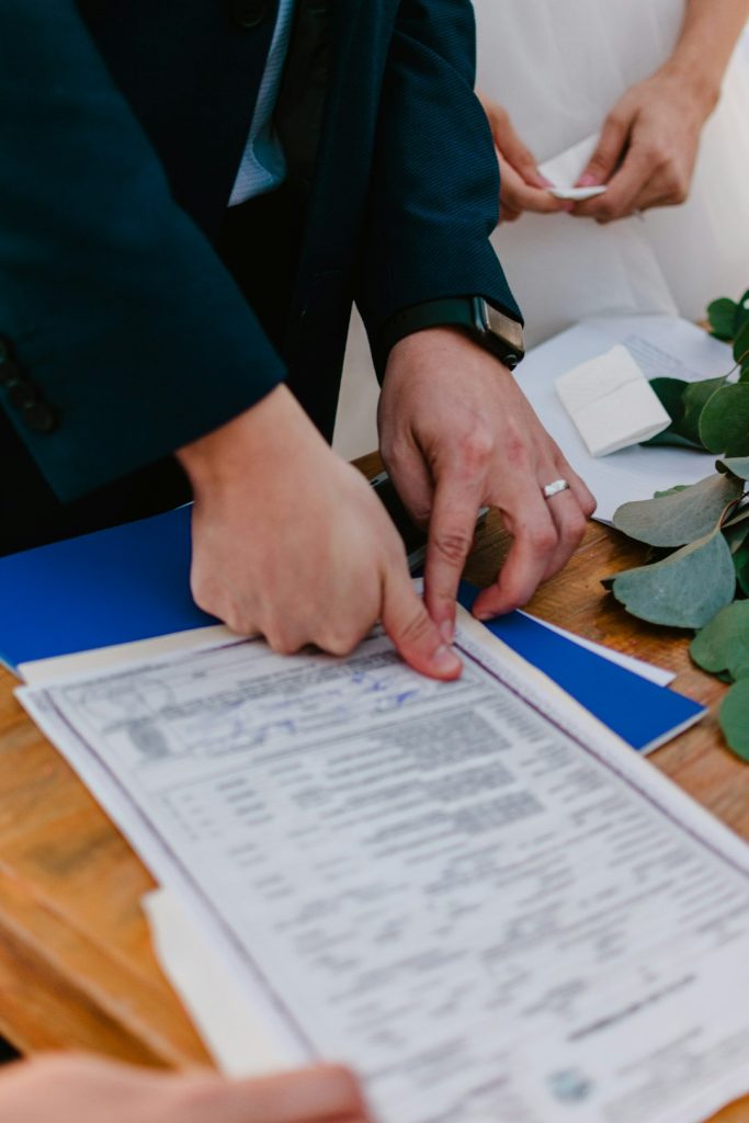 couple-signing-marriage-certificate-with-officiant-present-dffsfhpdric